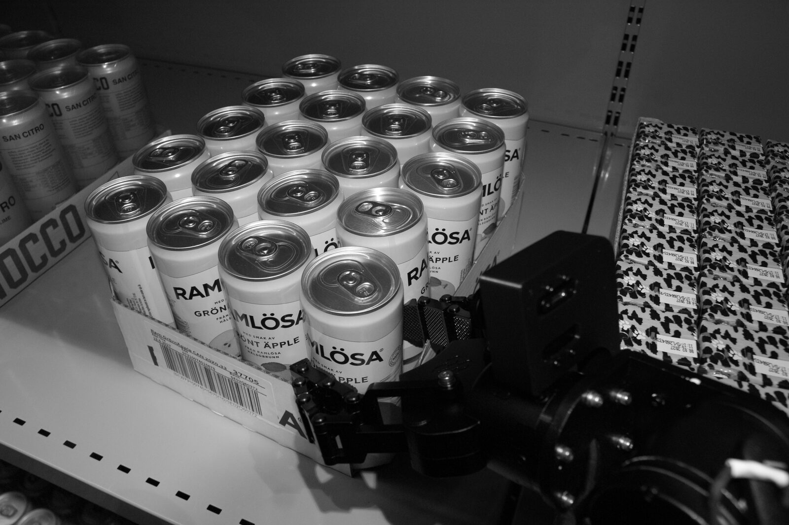 A Cota robot picking a case of cans from a store shelf
